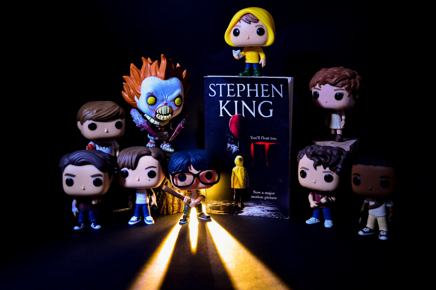 a group of action figures standing next to a book